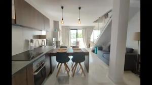 a kitchen with a table and two chairs in a room at Urb Jardines de Sotogrande dúplex, 120 m2, Piscina in Sotogrande