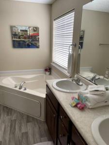 een badkamer met 2 wastafels, een bad en een spiegel bij Rocket city your home away from home. in Huntsville
