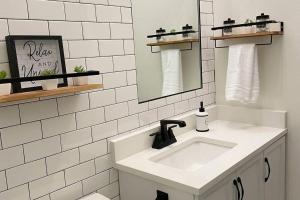a white bathroom with a sink and a mirror at Chateaus at St Clair in Downtown Little Rock in Little Rock