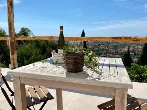 a picnic table with a bottle of wine and a plant at Villa Patrizia Pietrasanta in Pietrasanta