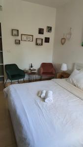 Una cama blanca con dos toallas plegables. en B resort דירת נופש בדרום רמת הגולן, en Giv'at Yo'av