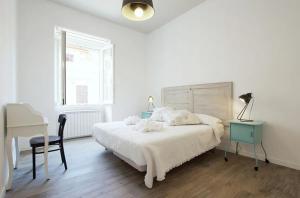 Habitación blanca con cama, escritorio y escritorio. en Trastevere Residence, en Roma