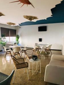 una habitación con mesas y sillas y un sofá en Costa De La Luz, en Huelva