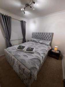 a bedroom with a bed with two plates on it at Ardfern Apartments in Airdrie
