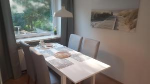 a dining room table with chairs and a window at Sea Cloud White Line in Eckernförde