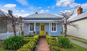 Casa blanca con puerta amarilla y entrada de ladrillo en Wild Cherry on Wishart, en Port Fairy