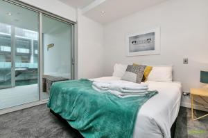 a bedroom with a bed with towels on it at QV Waterfront Apartment Viaduct Area - 503 in Auckland