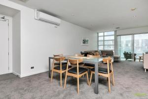 a living room with a table and chairs and a couch at QV Waterfront Apartment Viaduct Area - 503 in Auckland