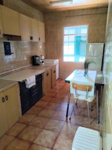 a kitchen with a table and a table and chairs at Casa Fidel. in Seoane