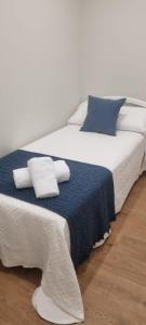 a large bed with blue and white sheets and pillows at CASA PEREIRAS in Pontevedra