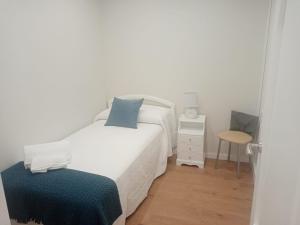 a small bedroom with a bed and a stool at CASA PEREIRAS in Pontevedra