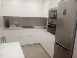 龐特維德拉的住宿－CASA PEREIRAS，厨房配有白色橱柜和不锈钢冰箱