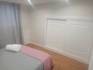 Un dormitorio con una cama con una manta rosa. en CASA PEREIRAS, en Pontevedra