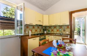 a kitchen with white cabinets and a wooden table at 3 Bedroom Cozy Home In Noto in Noto
