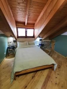 uma cama grande num quarto com tecto em madeira em El Puente Peregrino em Trabadelo
