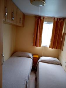 2 camas en una habitación pequeña con ventana en Casa del cristo, en Solórzano
