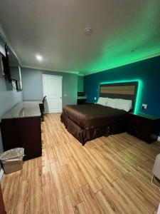 um quarto com uma cama e luz verde em BELL RESORT MOTEL em Bell