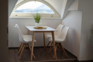 einen Tisch und Stühle in einem Zimmer mit Fenster in der Unterkunft Rooms21 in Schiefling am See