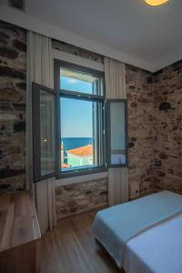 una camera da letto con una grande finestra con vista sull'oceano di Villa Samos - Renovated stone villa with private pool- 2 min from the sea! a Samos