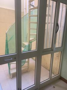szklane drzwi z widokiem na krzesło na zewnątrz w obiekcie Qronfli Holiday Apartments With Swimming Pool w mieście San Lawrenz