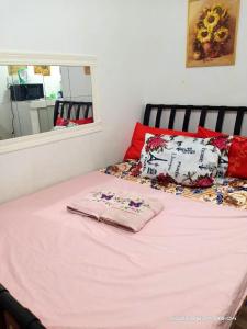 uma cama com um cobertor rosa e um espelho em 8 JOAQUIN'S Place WIFI Free! em Antipolo