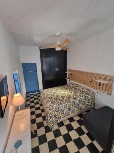 um quarto com uma cama e um piso em xadrez em CASA VERA em Vejer de la Frontera