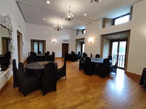 a large room with black chairs and tables and windows at Nap Palacio Marques de San Esteban in Figaredo