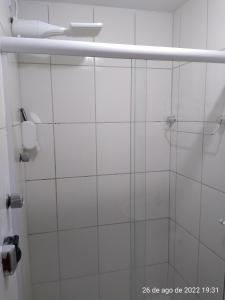 La salle de bains est pourvue d'une douche avec une porte en verre. dans l'établissement Cantinho Bonsai, à Rio de Janeiro