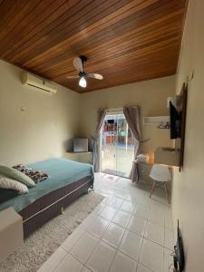 1 dormitorio con 1 cama con techo de madera en Smart Suíte en Boa Vista