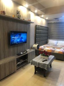 a living room with a television and a bed at Sea Residences MOA Manila by JO in Manila