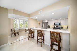 a kitchen with bar stools and a counter top at Luxury Beach Front Resort in Fort Myers Beach