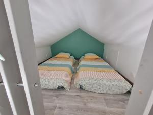 two beds in a small room in a attic at "les ecureuils"Logement indépendant climatisé in Veigné