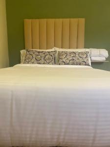 ein großes weißes Bett mit Kissen im Schlafzimmer in der Unterkunft Ayenda Hotel Bambu Guatape in Guatapé