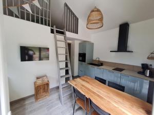 a kitchen with a wooden table and a ladder at "les ecureuils"Logement indépendant climatisé in Veigné