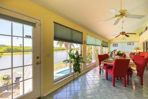 a dining room with a table and chairs and a view of the water at PEARL OF SANIBEL-Brand New to Rentals! in Sanibel