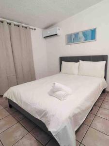 a bedroom with a white bed in a room at Life Is Good in Fajardo