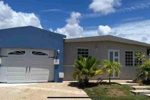 a large blue house with a garage at Life Is Good in Fajardo