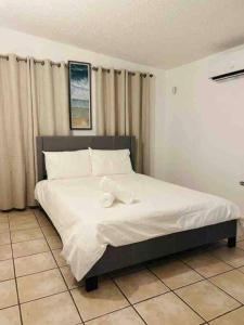a bedroom with a large bed with white sheets at Life Is Good in Fajardo