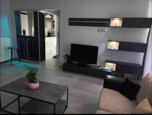 - un salon avec un canapé, une télévision et une table dans l'établissement Lovely Faliro Apartment next to the sea., à Athènes