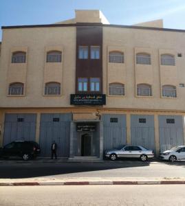 een gebouw met twee auto's ervoor geparkeerd bij شقق فندقية بن خليل /hôtel appartements Bin khlil in Tan-Tan