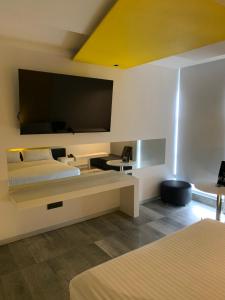San José de Otates的住宿－MOTEL BOUTIQUE GLAM，酒店客房设有两张床和一台平面电视。
