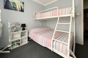 a bedroom with two bunk beds and a ladder at Braemar 9 in Forster