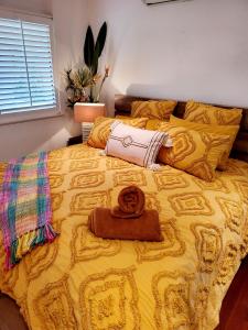 a large yellow bed with a towel on top of it at Eumundi Mountain Retreat in Eumundi