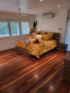 a bedroom with a bed and a wooden floor at Eumundi Mountain Retreat in Eumundi