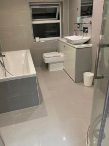 a white bathroom with a sink and a toilet at NKY CLASSIC BRIXTON APARTMENT Three in London