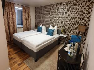 金策尔ARGENTA Living 16的卧室里有一张床，上面放着蓝色的枕头