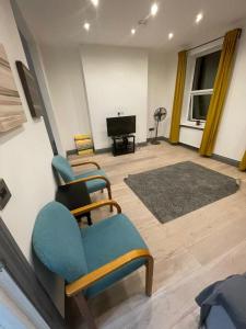 a living room with two chairs and a television at NKY CLASSIC BRIXTON APARTMENT Three in London