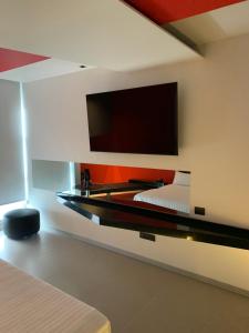 een slaapkamer met een bed en een flatscreen-tv aan de muur bij MOTEL BOUTIQUE GLAM in San José de Otates