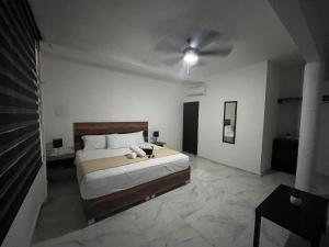 1 dormitorio con 1 cama y ventilador de techo en BALAM Playa - 15Th Ave en Playa del Carmen