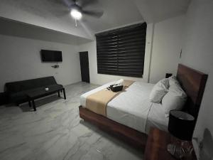 1 dormitorio con cama, sofá y TV en BALAM Playa - 15Th Ave en Playa del Carmen